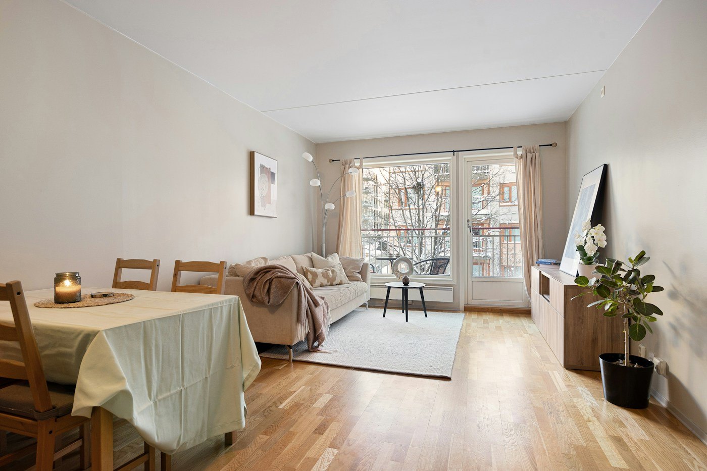 Light-filled living and dining space with natural timber and warm neutral finishes
